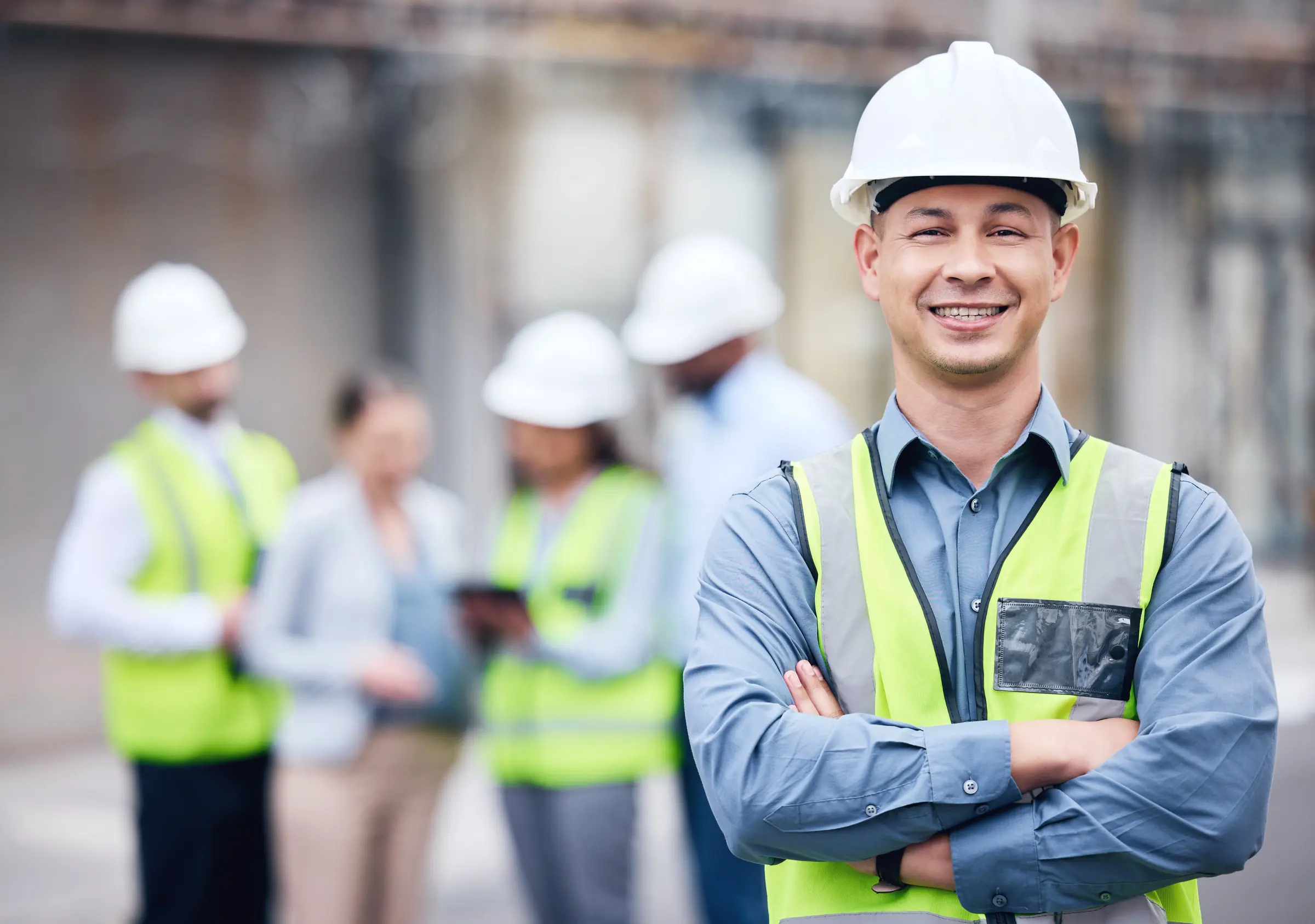 Engenheiro de segurança do trabalho com capacete e equipe com coletes refletivos