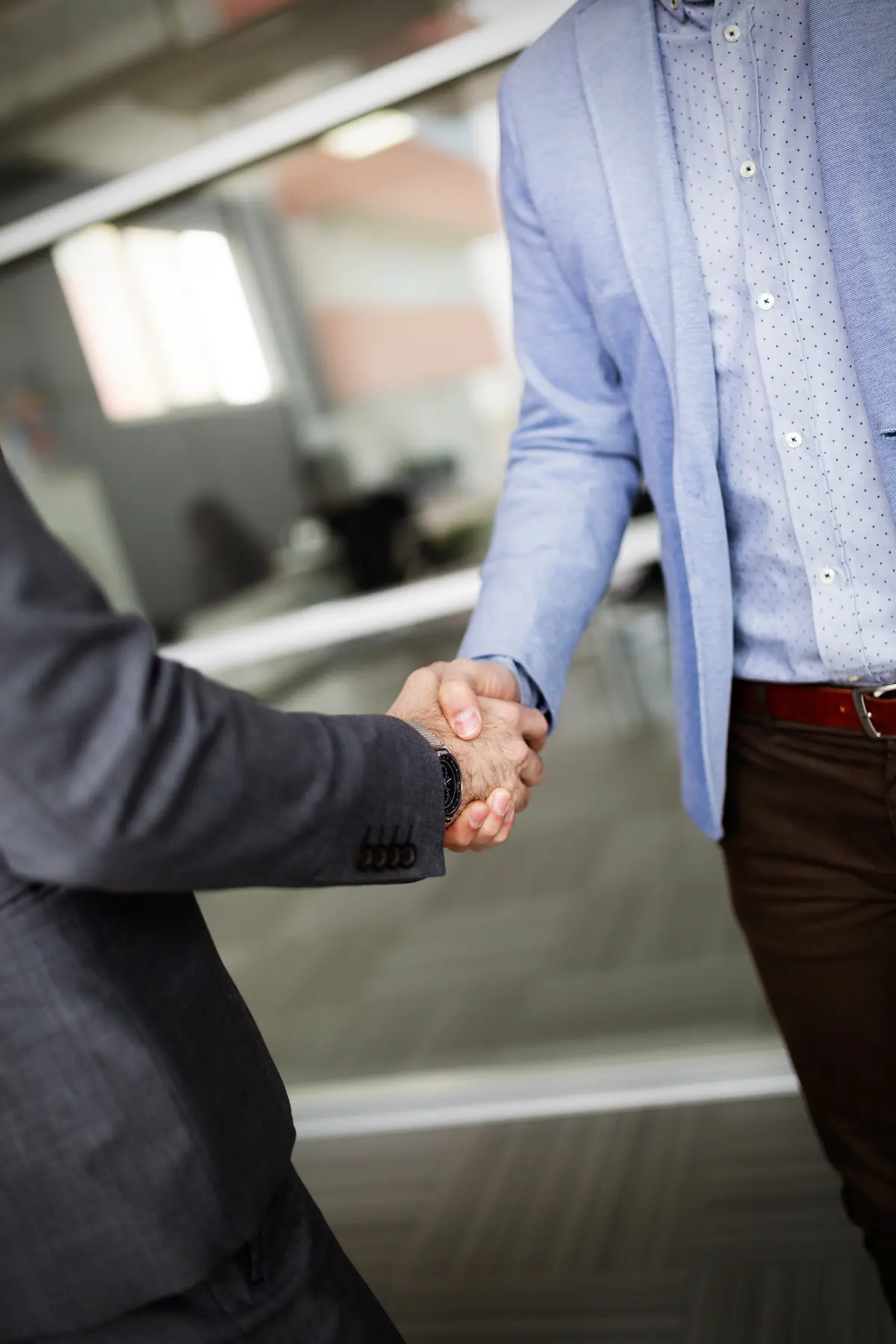 Aperto de mãos entre consultor de seguros e cliente empresarial