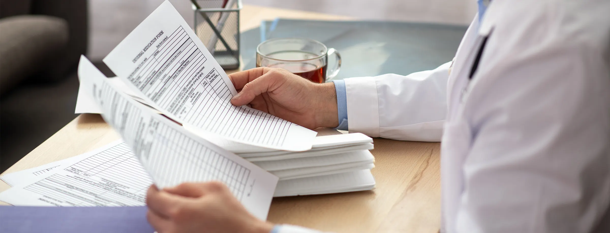 Profissional de saúde revisando laudos e documentos ocupacionais